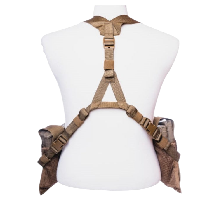 The Unissued US Marine Corps TAP Chest Rig Kit by Six Gun Surplus is displayed on a white mannequin torso. This tan tactical harness features multiple adjustable straps and buckles, with MOLLE pouches attached on both sides. The photo is taken from the back view, showcasing the structure and design of this low-profile platform.