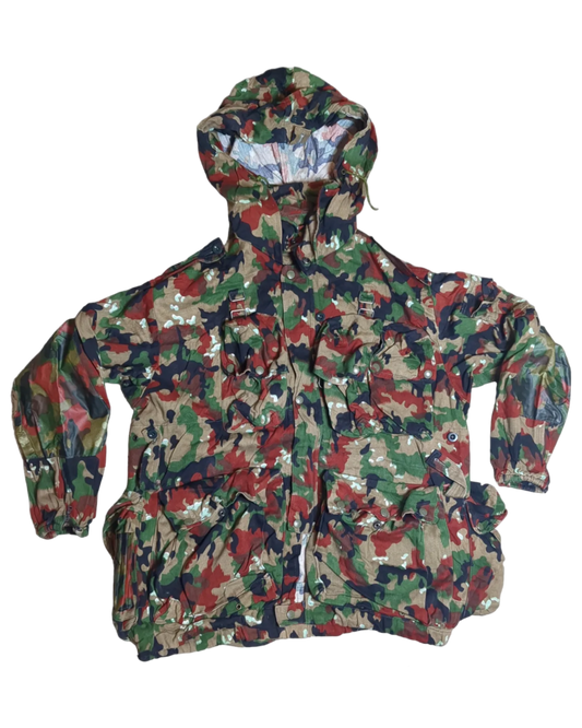 A hooded Six Gun Surplus Swiss Alpenflage M70 Field Jacket with a mix of green, red, brown, and black camouflage patterns. The jacket features several pockets on the front and adjustable cuffs and is laid flat on a solid black background.